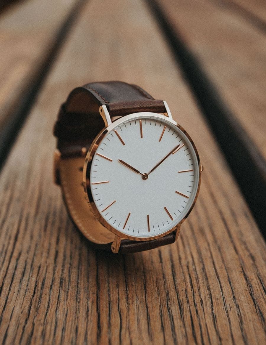 Gold analog watch with brown leather strap